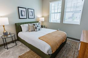 Burlingame apartment for rent - Bayswater Burlingame - Spacious Bedroom With Plush Carpet Flooring, Area Rug, Bed, Nightstands With Lamps, Dresser, Wall Art, And Two Windows With Blinds at Bayswater Apartments, Burlingame, CA
