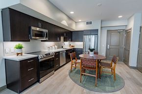 Burlingame apartment for rent - Eat-In Kitchen With Dining Room Table, Black Cabinets, White Countertops, And Stainless-Steel Appliances. at Bayswater Apartments, Burlingame, 94010