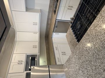 Corona townhouse for rent - A kitchen with white cabinets and a counter top.