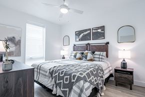 Oklahoma City apartment for rent - A bedroom with a bed, nightstands, and a ceiling fan.
