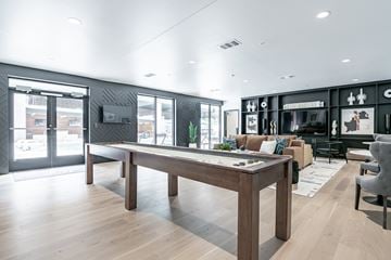 Oklahoma City apartment for rent - A modern living room with a long wooden table and a variety of seating options.