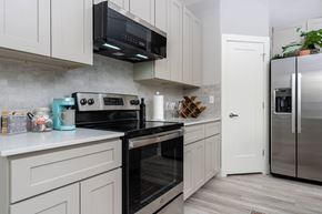 Taylor apartment for rent - model kitchen with stainless steel appliances and white cabinets at Mihir Taylor, Taylor, TX