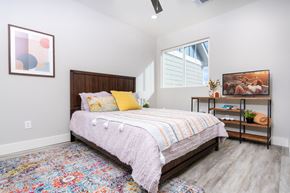 Taylor apartment for rent - Bedroom with Full-Size Bed, Window, and Wood-Style Flooring at Mihir Taylor, Taylor, Texas