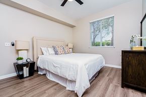 Chino Hills apartment for rent - Two-Bedroom Apartments in Chino Hills, CA - Missions at Chino Hills - Spacious Bedroom With Upholstered Bed, Ceiling Fan, Nightstands With Lamps, Wood Style Flooring, And Window With Blinds.