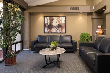 Scottsdale apartment for rent - A living room with a large painting on the wall and a potted plant on the table.