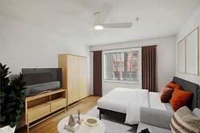 Seattle apartment for rent - A modern bedroom with a large bed and a television.