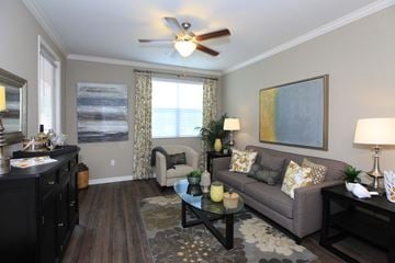 Riverside apartment for rent - a living room with a ceiling fan and a couch