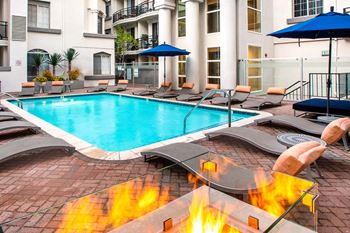 Resort inspired pool with lounge seating and a firepit