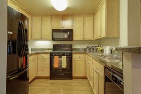 Van Nuys apartment for rent - A kitchen with wooden cabinets and a black oven.at 6940 Sepulveda, Van Nuys, 91405  