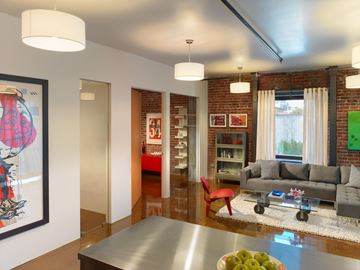 San Francisco apartment for rent - A modern living room with a grey couch and a red chair.