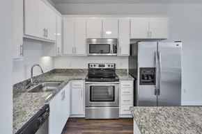 San Jose apartment for rent - a kitchen with white cabinets and granite counter tops and stainless steel appliances at Aviara Apartments, San Jose, CA
