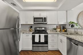 Phoenix apartment for rent - a kitchen with stainless steel appliances and white cabinets at Vaseo Apartments, Arizona, 85022