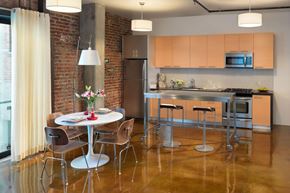 San Francisco apartment for rent - A kitchen with a table and chairs in front of a brick wall.