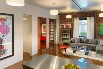 San Francisco apartment for rent - A modern living room with a grey couch and a red chair.