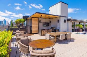 San Francisco apartment for rent - A modern outdoor dining area with a wooden table surrounded by chairs.