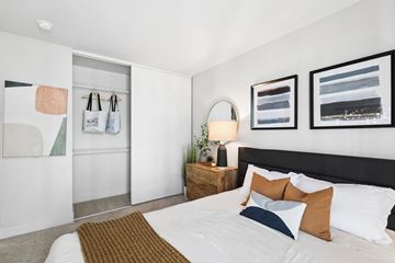 Fremont apartment for rent - A bedroom with a bed, nightstand, and two wall hangings.