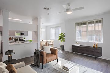 Sacramento apartment for rent - A modern living room with a brown leather couch and a glass coffee table.