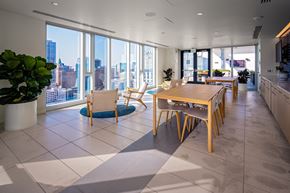 Oakland apartment for rent - A modern kitchen with a dining table and chairs in front of a large window overlooking a cityscape.