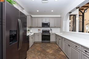 Murrieta apartment for rent - A modern kitchen with a refrigerator on the left and a stove on the right. at Sonoma at Mapleton Apartments, West Murrieta, 92563