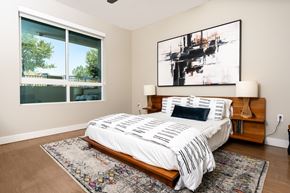 Redlands apartment for rent - A bedroom with a large bed and a painting on the wall.