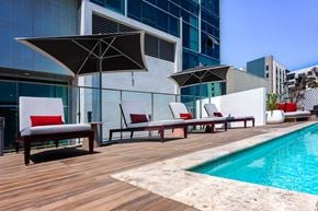 Los Angeles apartment for rent - a poolside deck with lounge chairs and umbrellas