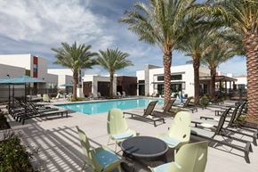 Sacramento apartment for rent - a swimming pool with chairs and tables and palm trees