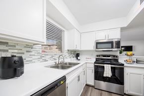 El Paso, Tx apartment for rent - A modern kitchen with white cabinets and stainless steel appliances.