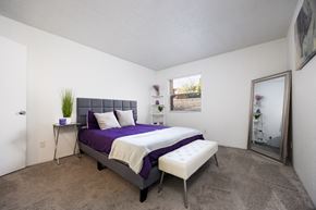 El Paso, Tx apartment for rent - A bedroom with a purple bed and a white chair.