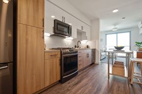 Berkeley apartment for rent - Three-BR Apartments In Downtown Berkeley, CA - The Addison - Designer Kitchen With Black Stainless Steel Appliances, 2-Color Custom Kitchen Cabinetry With Silestone Quartz Countertop and Designer Backsplashes, Hardwood Floors Leading To Living Room