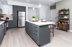 Corona apartment for rent - a kitchen with a center island and a stainless steel refrigerator
