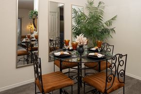Surprise apartment for rent - A dining table with chairs and a mirror reflecting a dining room.