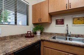 Surprise apartment for rent - A kitchen with a black dishwasher and a granite countertop.
