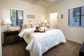 Surprise apartment for rent - 3 Bedroom Apartments in Surprise, AZ - The Village at West Point - A Bedroom With A White Comforter, Neutral Accent Pillows, Matching Nightstands With Lamps, And Two Windows With Blinds.