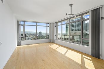 A room with a view of the city through large windows.