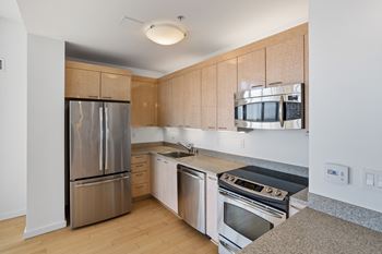 A kitchen with a refrigerator, oven, and microwave.