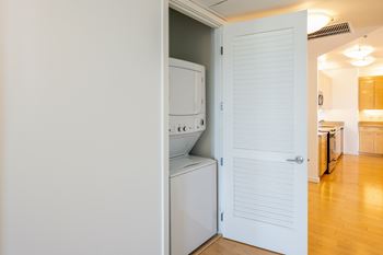 A white door is open to a kitchen.