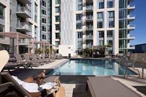 Sunnyvale apartment for rent - A person is sunbathing by a pool in front of The Martin
