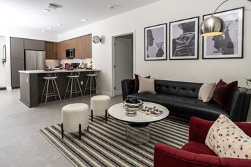 Monrovia apartment for rent - A modern living room with a red couch and a striped rug.