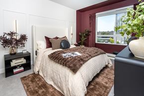 Monrovia apartment for rent - A bedroom with a large bed and a window overlooking a cityscape.