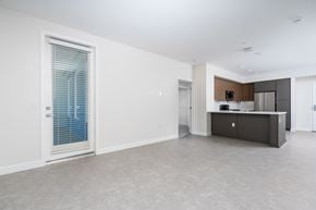 Monrovia apartment for rent - A spacious, empty room with a window, a counter, and a door.