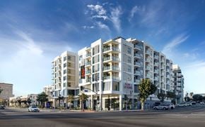 San Pedro apartment for rent - A large white apartment building with a red sign that says "Now Leasing" is under a blue sky.