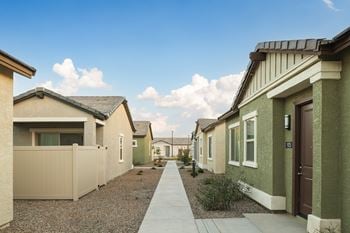 A row of houses with a sidewalk 
