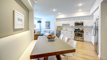 A modern kitchen with a dining table and chairs.