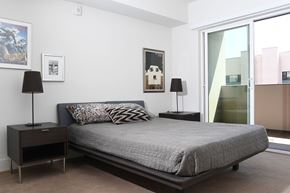 Los Angeles apartment for rent - A bedroom with a bed, nightstands, and a poster on the wall at Wilshire Valencia Apartment, Los Angeles, 90017