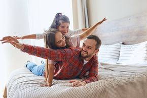 Upland apartment for rent - a man and woman laying on a bed with their daughter