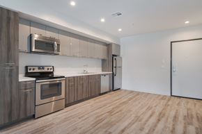 Los Angeles apartment for rent - A modern kitchen with wooden cabinets and stainless steel appliances at Wilshire Valencia Apartment, California, 90017