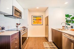 San Francisco apartment for rent - A kitchen with a modern design featuring a stainless steel oven and microwave.at Ansel, San Francisco, CA 94103