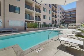 Los Angeles apartment for rent - A pool area with a pool and sun loungers at Wilshire Valencia Apartment, California