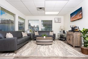 Alta Loma apartment for rent - Modern waiting room with gray sofas and coffee table at Woodbend Apartments, California