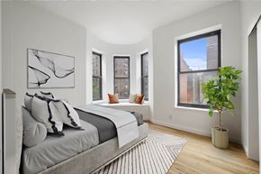 New York apartment for rent - A bedroom with a large bed and a plant.